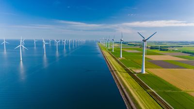 Wind turbines harnessing the power of the breeze create sustainable energy along the scenic Dutch landscape, reflecting a commitment to green technology.