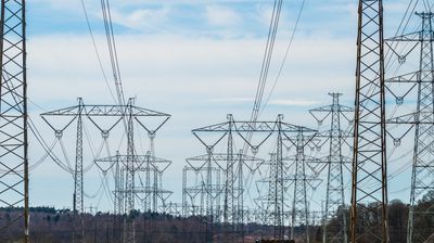 Torres de transmisión eléctrica en un paisaje rural abierto.