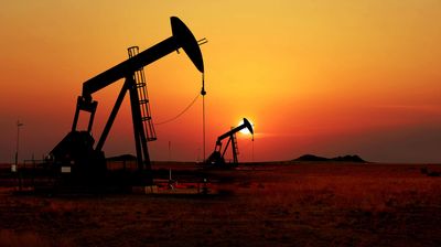 Silhouette of oil pump jacks at sunset in a desert field. Symbolizes Iranian oil production, energy crisis, and rising crude prices amidst escalating Middle East conflicts and Hormuz Strait tensions.