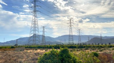 Electric tower. High voltage electricity pylons and transmission power lines in farm field. Electric tower in field. Power line towers in farmland. Electricity pylons and High voltage at mountains.