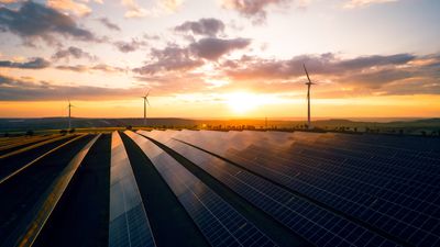 Green energy reduce carbon emissions and makes earth cleaner and more ecological.Clean and environmental.Photovoltaic power station and wind turbines at sunset.Windmill turbines generating energy.