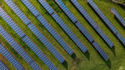 Rows of photovoltaic solar panels on agricultural land generating clean sustainable energy for business and domestic purposes