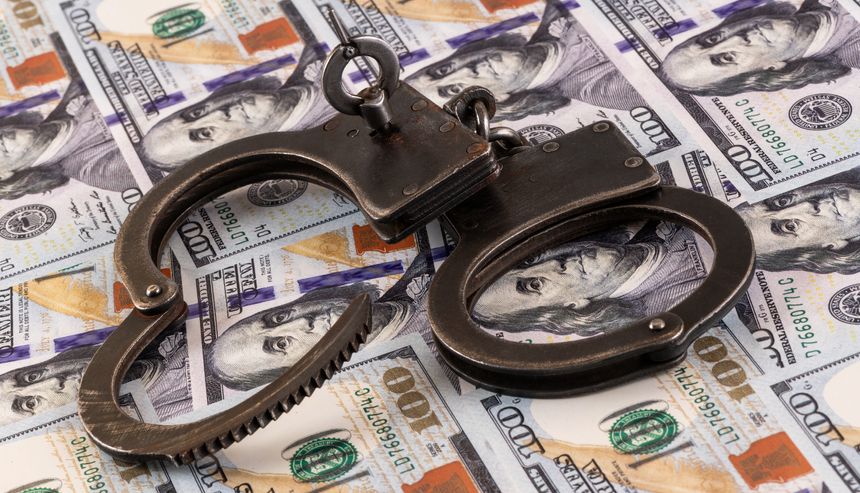 Handcuffs against the background of 100 US dollar bills