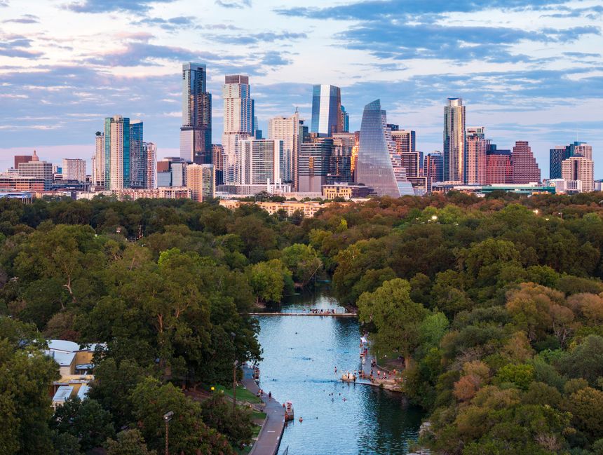 Aerial drone view of the Austin Texas skyline at sunset seen from above the Barton Springs swimming pool on a warm fall evening