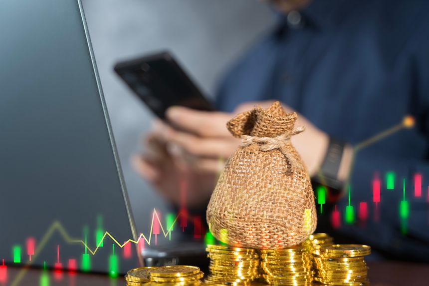 Money bag with stacked gold coins on table and colorful candlestick chart background, symbolizing financial investment, wealth growth, trading, cryptocurrency and successful business strategy planning