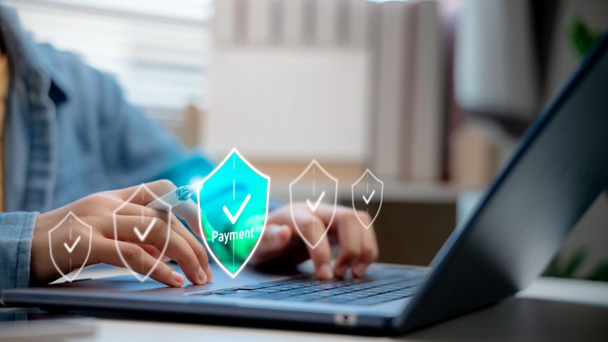 Woman using stylus and laptop with payment security icon on digital screen. Concept of secure online transaction, fintech system, and digital payment verification.