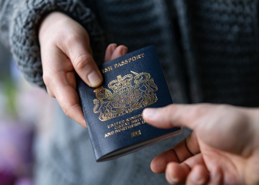 man handing new post Brexit blue British passport Devon, United Kingdom, January, 2021.
