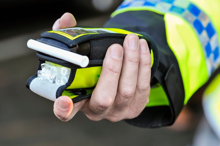 Belfast, Northern Ireland. 24 Nov 2016 - A police officer holds a roadside breathalyser alcohol breath test after taking a sample from a driver.