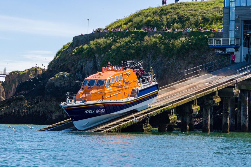 RNLI Tamar class offshore lifeboat "Haydn Miller" launches from the slipway at the lifeboat station in the resort town of Tenby, Pembrokeshire, Wales