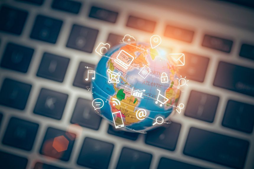 Media icons fly off around the globe on laptop. Lens flares and warm glow in image. Vignette at corners.