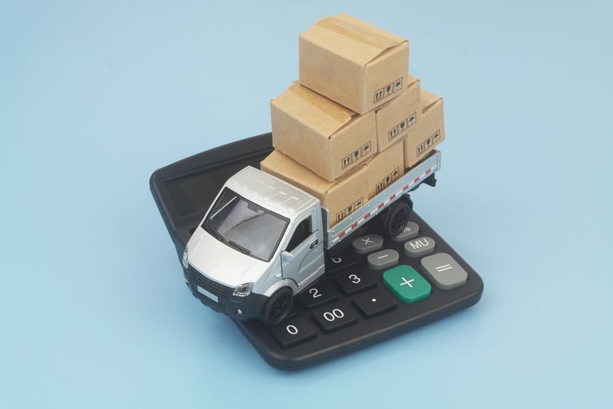 Lorry truck with many boxes on calculator. Cost of freight transportation and tariffs concept