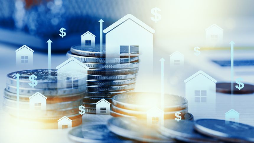 Stacks of coins with house icons rising above them show investment growth in real estate.