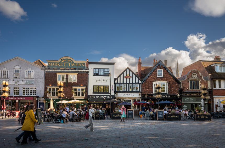 Salisbury, Wiltshire, UK - Aug 29 2025: The Market Place in central Salisbury showing Ox Row. People sit outside local pubs enjoying a drink in the evening sunshine.