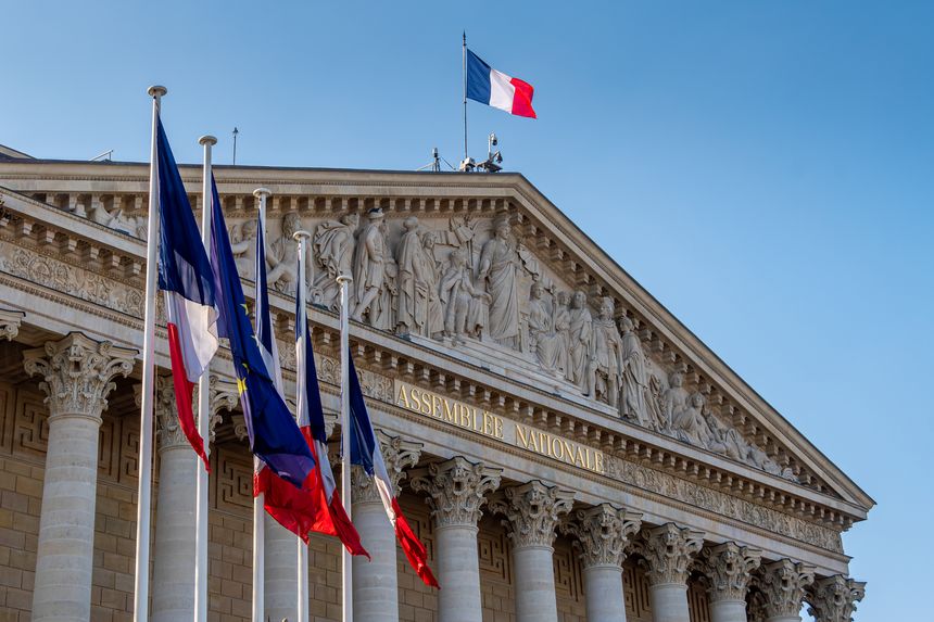 Paris, France - February 14, 2025: Flags and facade of the National Assembly building (Assemblée Nationale), aka Palais Bourbon or chamber of deputies, elected representatives in the French parliament