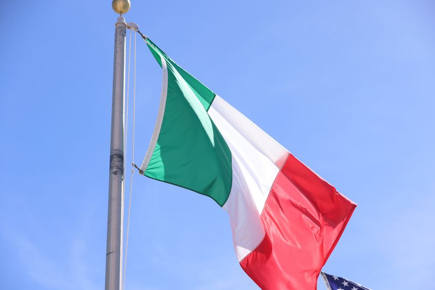 National Flag of Italy Waving on Silver Pole Against Clear Blue Sky Background