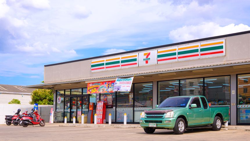 Samut Sakhon, Thailand - August 14, 2025 : Large 7-eleven convenience store with customer service parking lot area against blue sky background, side view