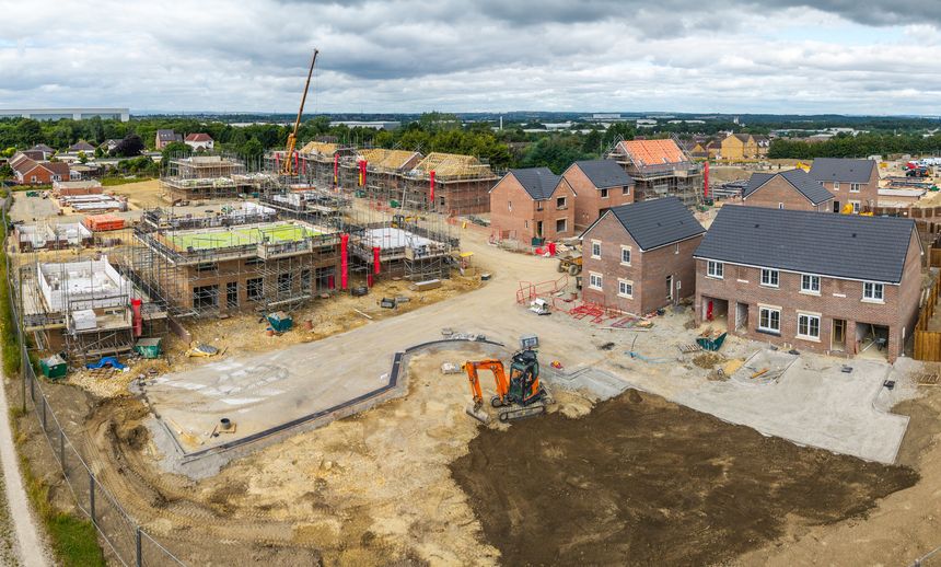 Aerial landscape view above a construction site building new and affordable eco friendly houses to fill the housing shortage in the UK on green belt land