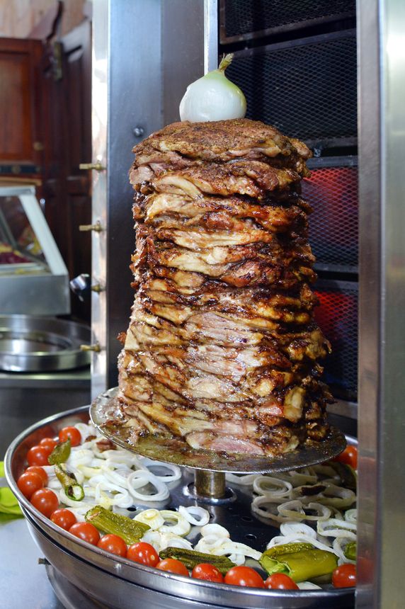 Doner kebab roasted on rotating spit. Food background texture.