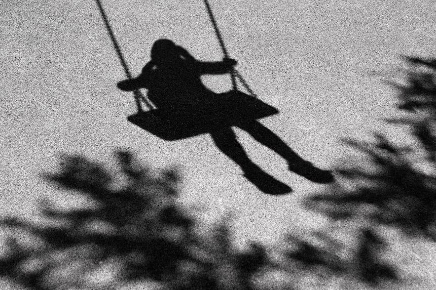 Blurry shadows of girl on a swing and a tree branch
