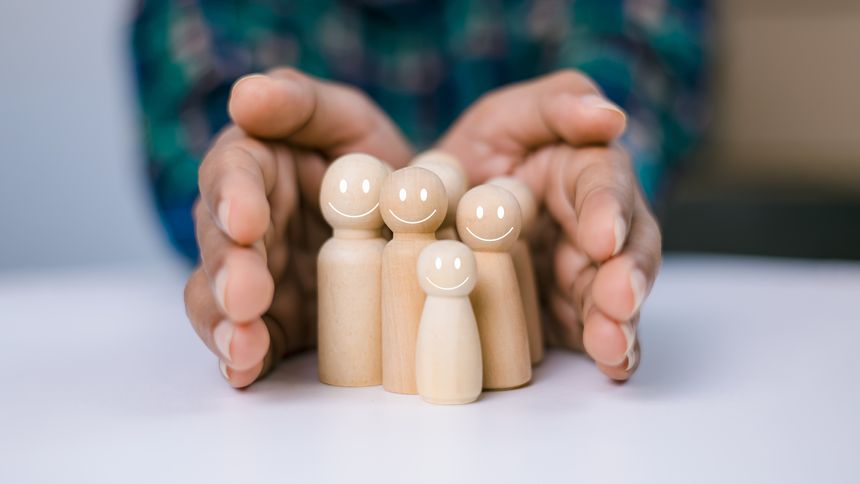 Concept of insurance and protection, Insurance management planning, Health care and finance, Hand of a person laying down protection a wooden dolls to show represents the protection of family safety.