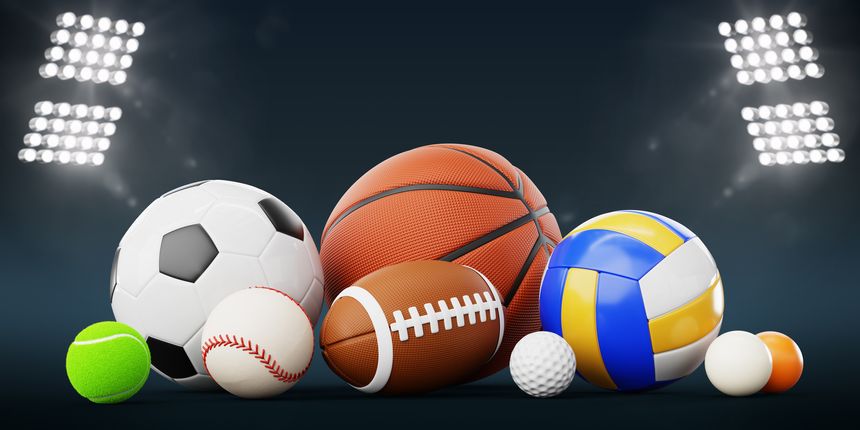3d sports balls pile in stadium illuminated by floodlights at night. American football, soccer, basketball, baseball, volleyball, golf, tennis game equipment on dark blue background. 3D illustration