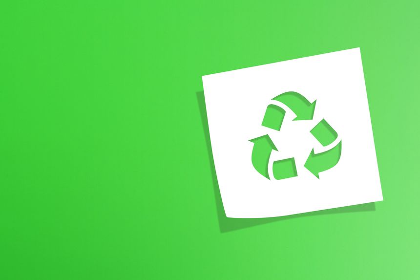 Note paper with recycle symbol on green background