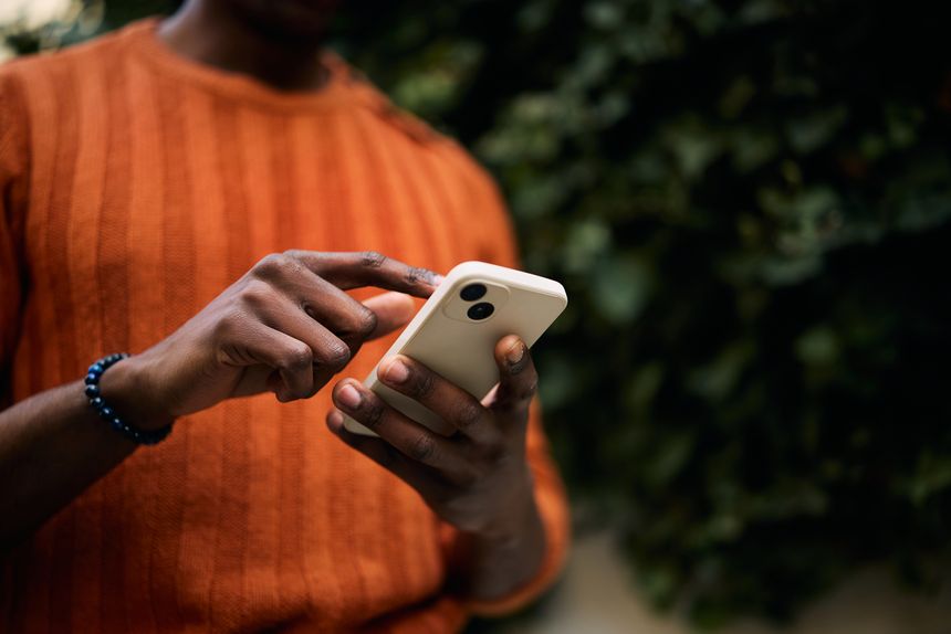 Close up of African American man using app on smart phone. Copy space.
