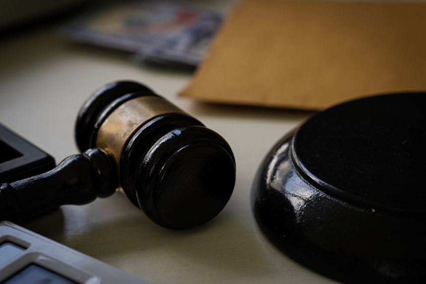 The judge's hammer is placed on the table and there is money in the background in the debate room for a fair judgment. Economic Concepts of Fraud and Punishment of Judicial Systems