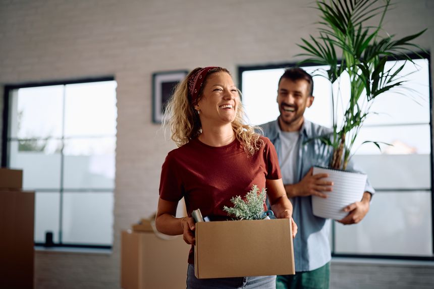 Happy couple bringing their belongings into new home. Copy space.