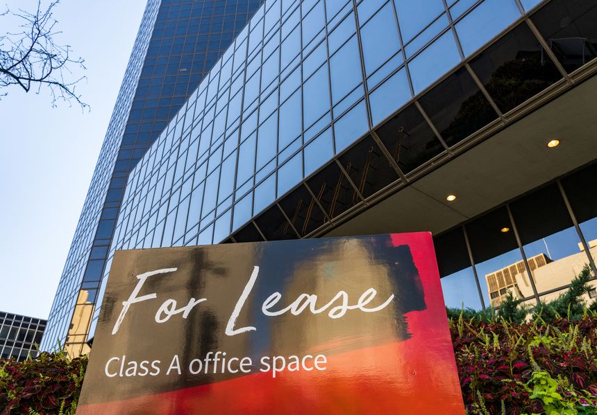 For Lease sign in front of mirrored surface of a modern skyscraper in St Louis