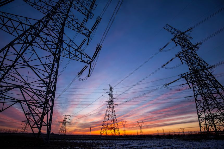 The silhouette of the evening electricity transmission pylon