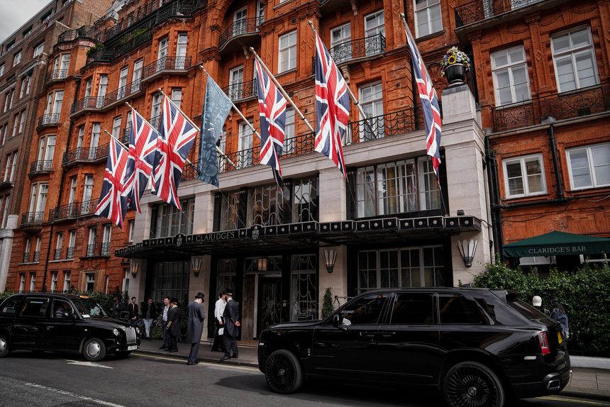 London, England, United Kingdom (UK), Britain, Europe – On July 12, 2024: A daytime shot capturing the Union Jack flag, British Union Flag - the flag of the United Kingdom, displayed on the elegant facade of Claridge's Hotel on Brook Street, located on Brook Street in the prestigious London W1 area; black cabs, people, and luxury cars, & pedestrians create a lively atmosphere.