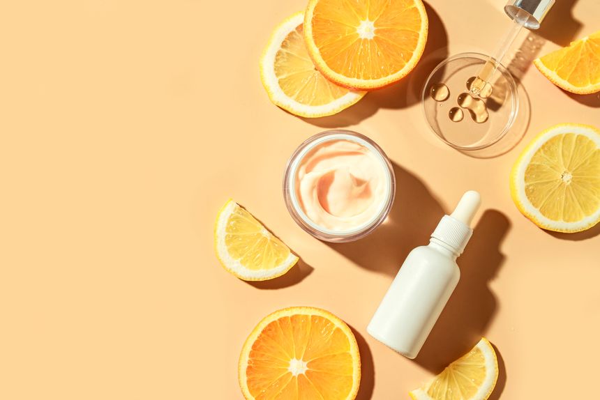 Natural vitamin C serum and face cream, skin care, essential oil products. Cosmetic products and fresh citrus lemon and orange fruit slice, bright trendy layout.