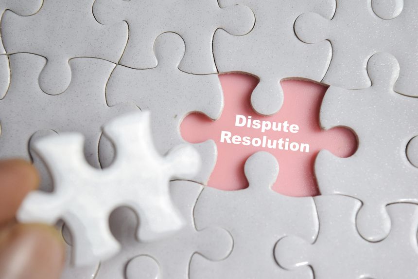 Hand holding piece of jigsaw puzzle with word Dispute Resolution. Business and finance concept
