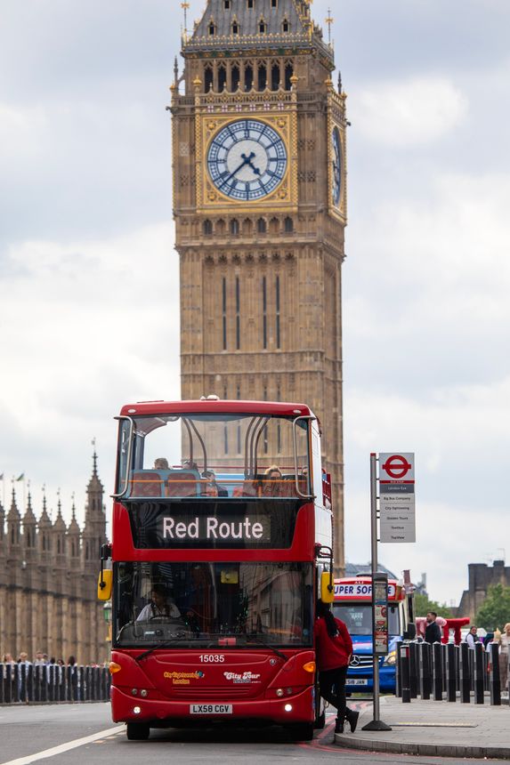 London, UK - June 3rd 2024: A sightseeing bus at a bus stop on Westminster Bridge with the Elizabeth Tower in the background, in London, UK.