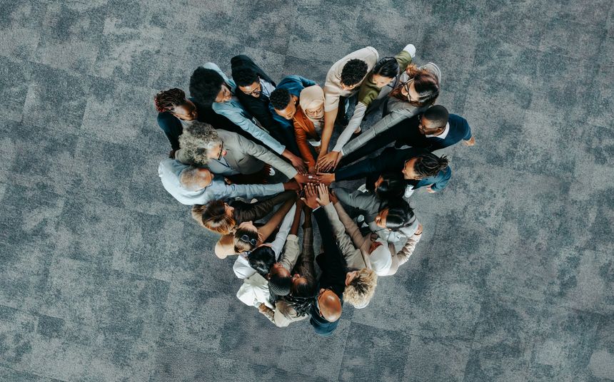 A diverse business group standing in a heart formation, symbolizing unity, teamwork, and collaboration.