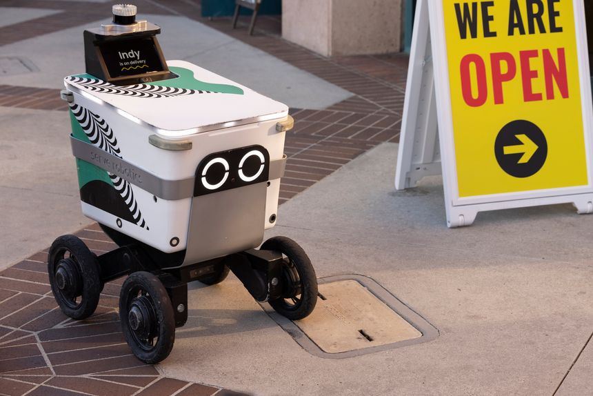 Glendale, California, USA - March 15, 2025: A wheeled Serve Robotics delivery robot makes a delivery on a city street.