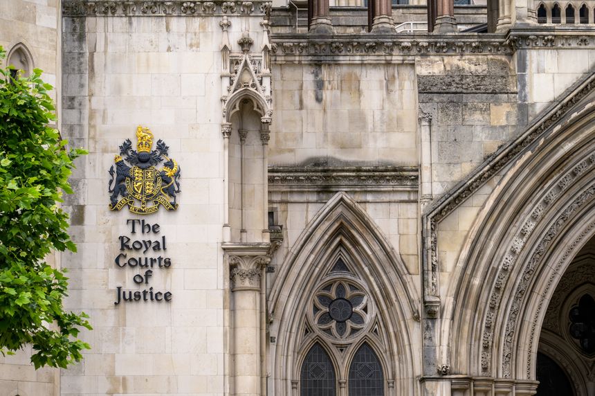 LONDON - May 21, 2022: Coat of Arms and sign on side of The Royal Courts of Justice building