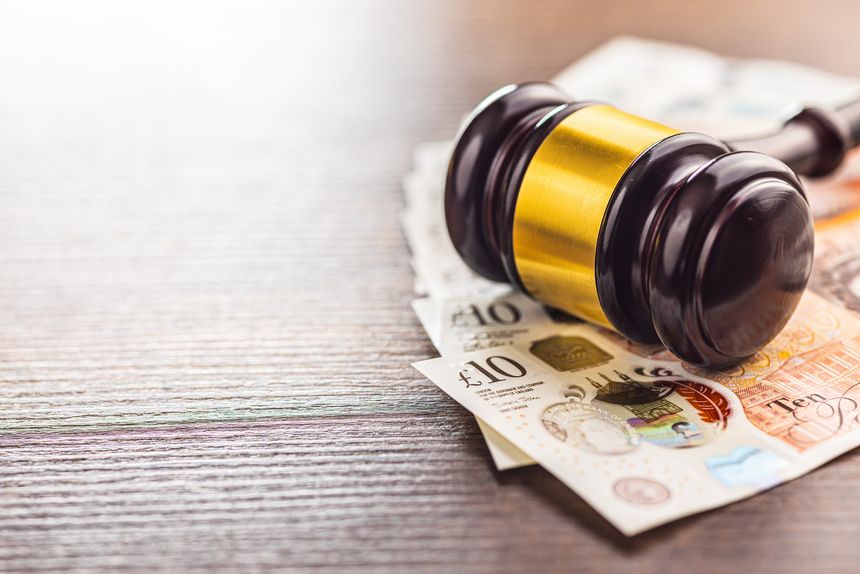 Judge gavel and british pound sterling on the wooden table.