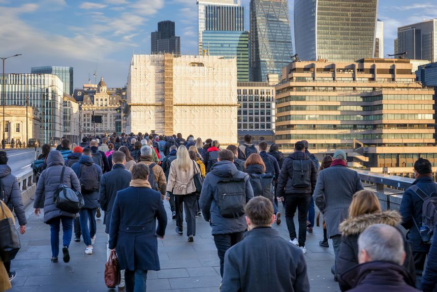 Crowds of commuters on London Bridge rushing into the City offices during sunrise