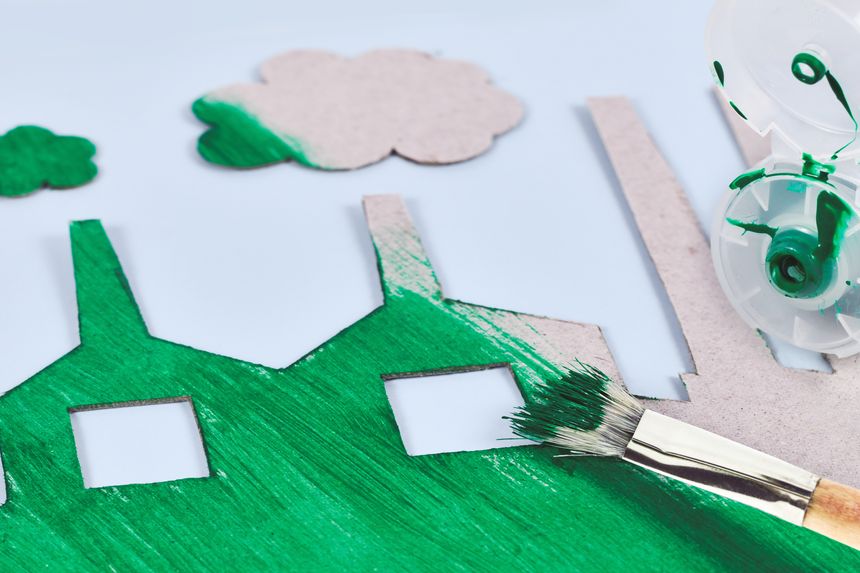 Greenwashing concept with cardboard factory being painted green