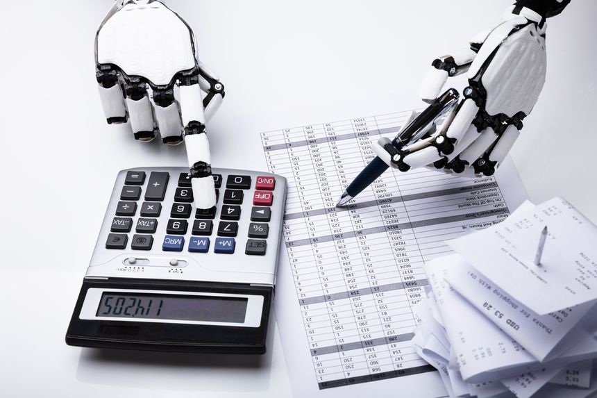 Close-up Of Robot Examining Financial Report With Calculator On Desk