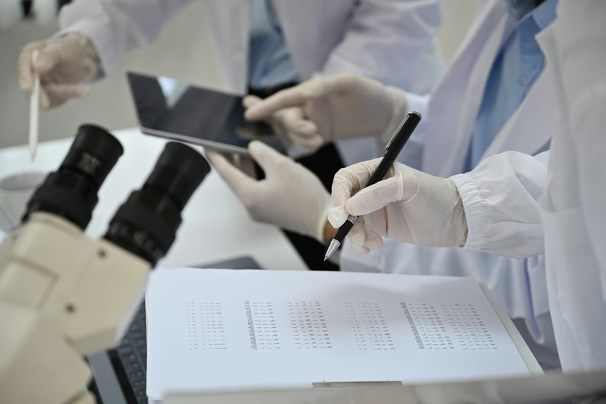 Close-up of the lab team scientist experimental experts of various ages Discuss research and Record their experimental data at the lab. Teamwork, technicians, scientific professionals.