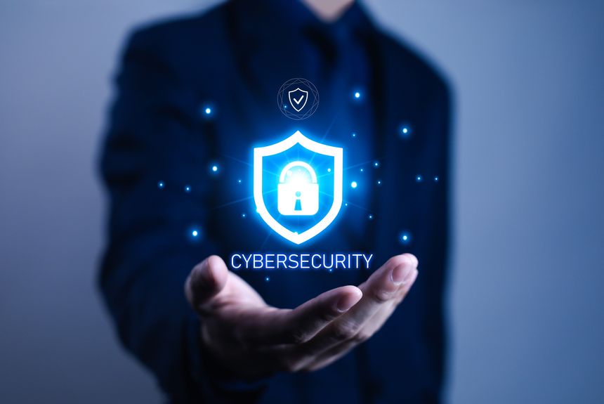 Businessman hand holding glowing digital shield with padlock icon, symbolizing cybersecurity, data protection, network privacy, online safety, encryption, and secure information technology concept.