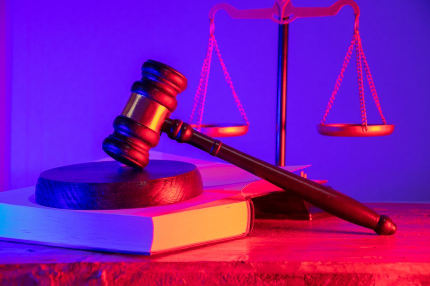Wooden gavel on a statute book with scales of justice. The inviolability of the judicial system. Legal decisions and the concept of fairness in court