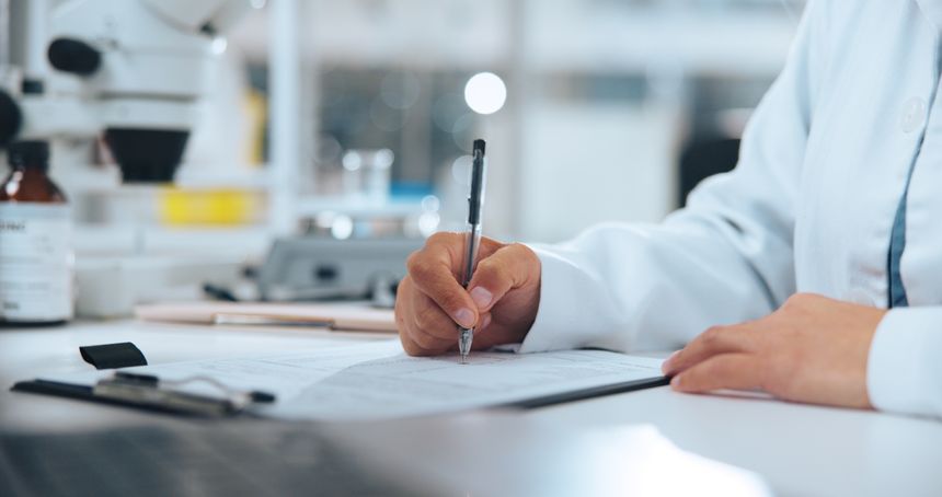 Hand, science and writing with doctor in laboratory for medical development or research results. Clipboard, notes and paperwork with scientist at work on clinic trial, experiment or investigation