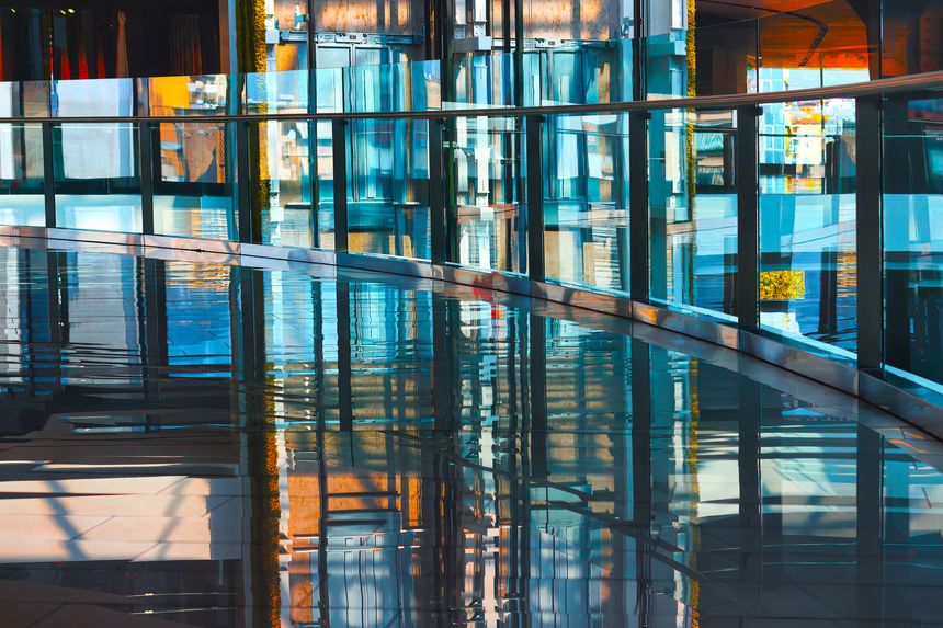 Empty corridor of modern office building with reflection in glass. Abstract background with colorful lights