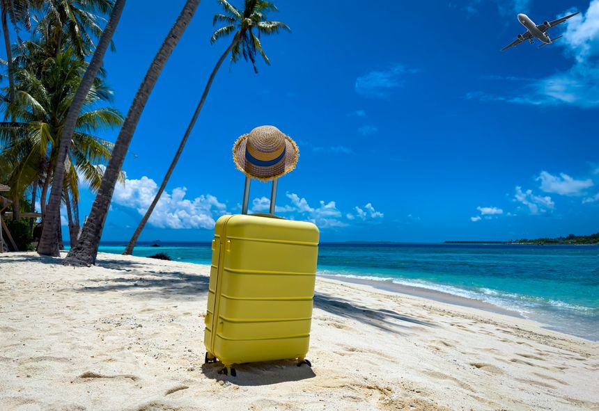 The yellow luggage on the beach- summer travel concept