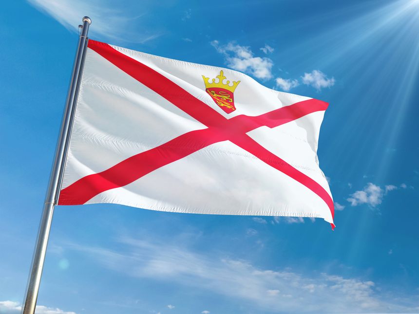 Jersey National Flag Waving on pole against sunny blue sky background. High Definition