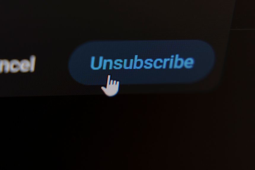 Mouse cursor clicking unsubscribe button on dark screen interface. High quality photo